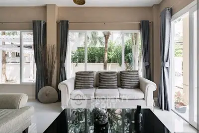 Elegant living room with large windows and modern decor, perfect for relaxation.