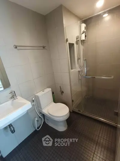 Modern bathroom with glass shower and sleek fixtures in a contemporary apartment.
