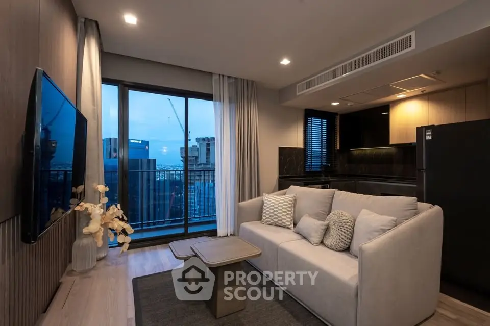 Modern living room with city view, stylish decor, and open kitchen layout.