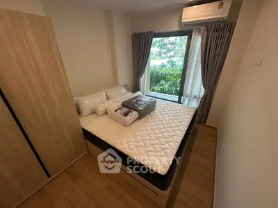 Cozy bedroom with large window and modern furnishings, perfect for relaxation and comfort.