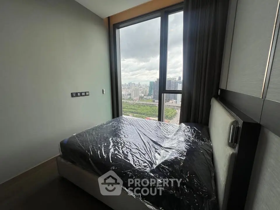 Modern bedroom with large window offering stunning city view