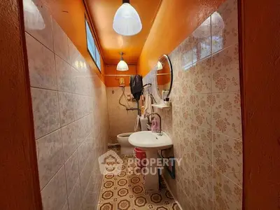 Charming vintage bathroom with floral tiles and warm lighting, perfect for a cozy home ambiance.
