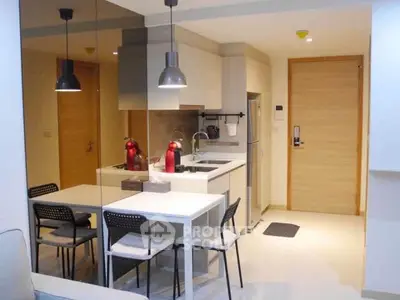 Modern kitchen with sleek design and dining area in a cozy apartment.