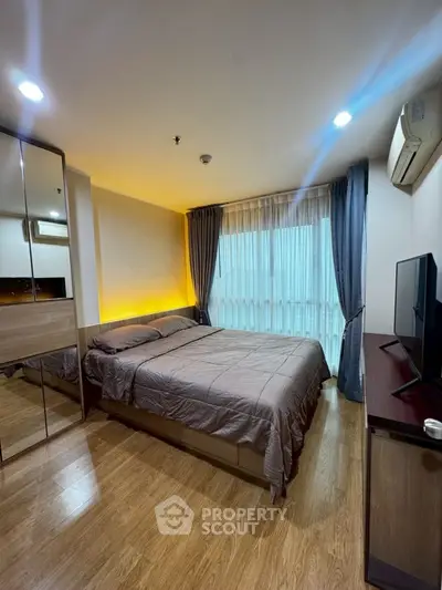 Modern bedroom with cozy lighting and wooden flooring in a stylish apartment.