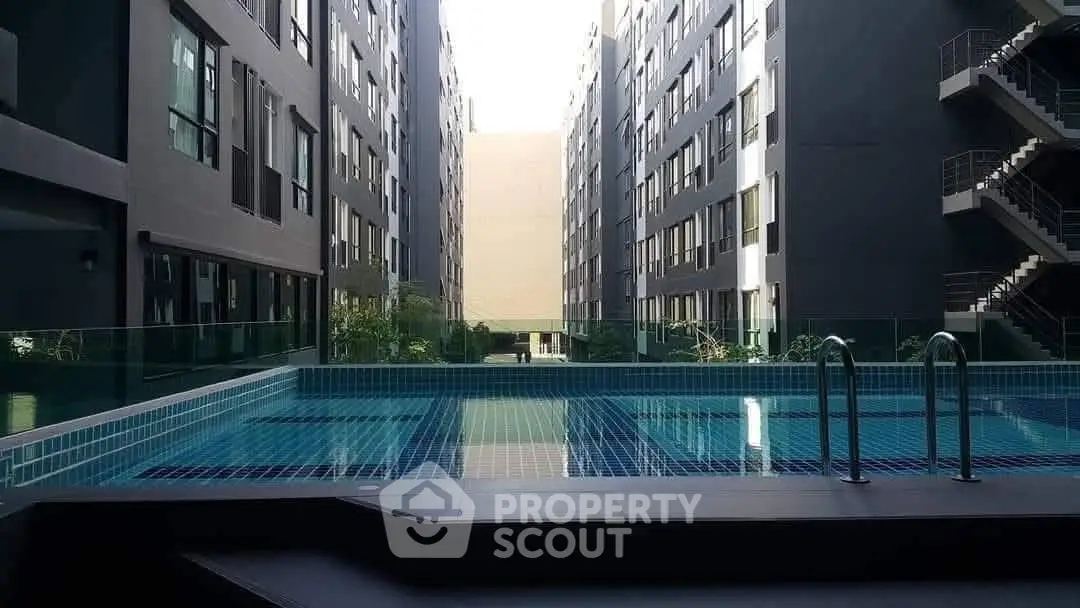 Modern apartment complex with inviting swimming pool and sleek architecture.