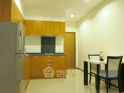 Modern kitchen with wooden cabinets and dining area in a cozy apartment