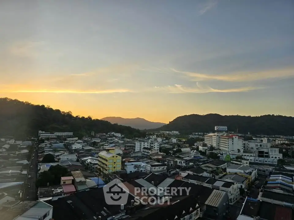 Stunning sunset view over a vibrant cityscape with hills in the background.