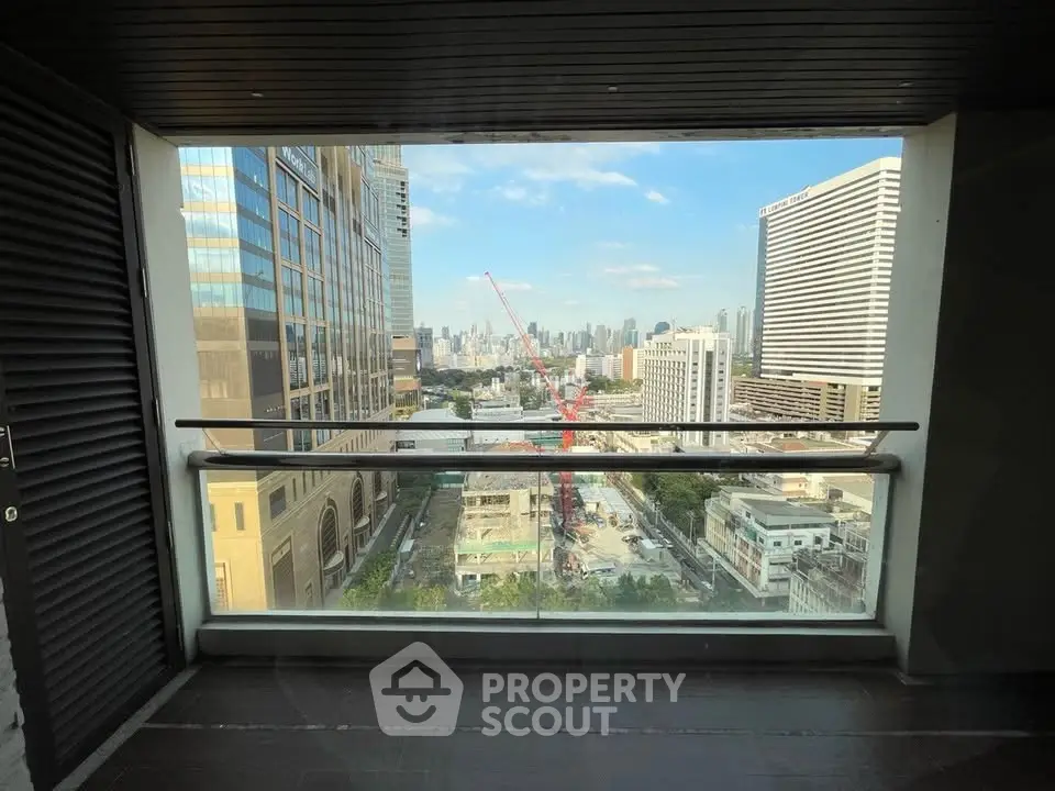 Stunning cityscape view from a modern balcony with glass railing.