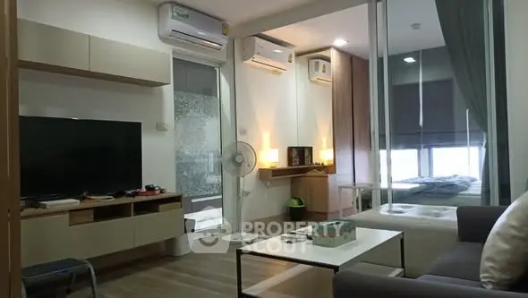 Modern living room with sleek furniture and large TV in a stylish apartment.