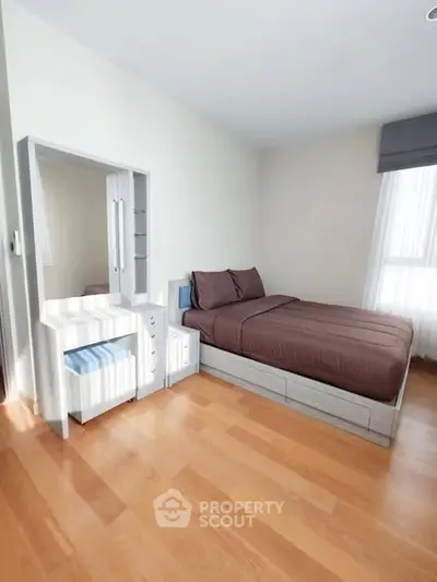 Bright and cozy bedroom with wooden flooring and modern furniture