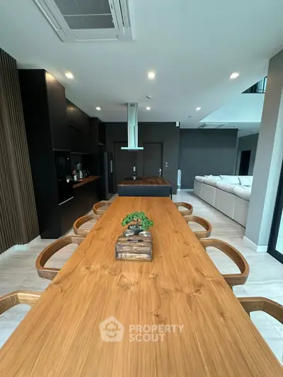Modern open-plan living and dining area with sleek kitchen and stylish wooden table