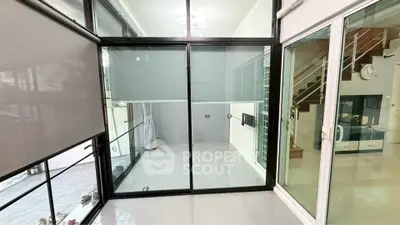 Modern interior with glass sliding doors and staircase, ideal for contemporary living.