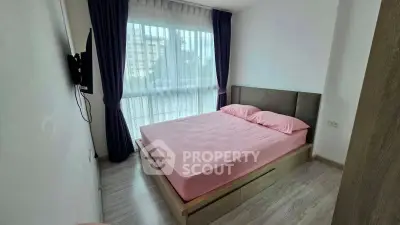 Cozy bedroom with large window and pink bedding in modern apartment
