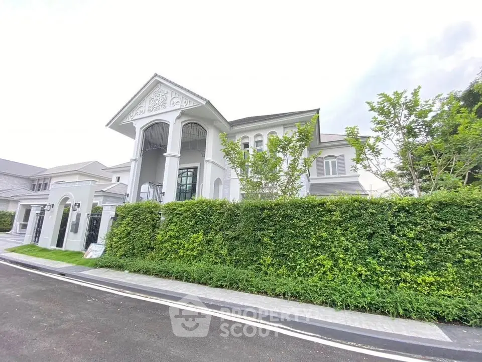 Luxurious mansion with elegant architecture and lush greenery in a prestigious neighborhood.