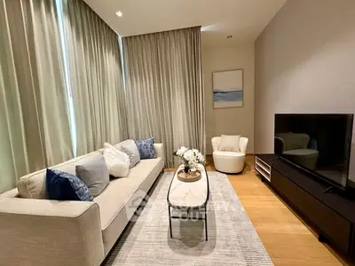 Elegant modern living room with cozy sofa, stylish decor, and large TV, perfect for relaxation and entertainment.