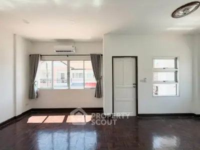 Spacious and bright living room with large windows and elegant flooring