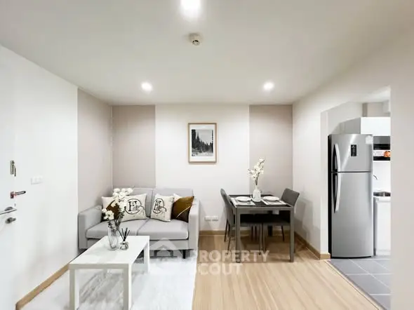 Modern living room with cozy sofa and dining area in open layout apartment.