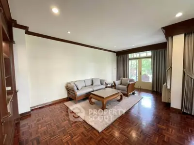 Spacious living room with elegant wood flooring and cozy seating area.