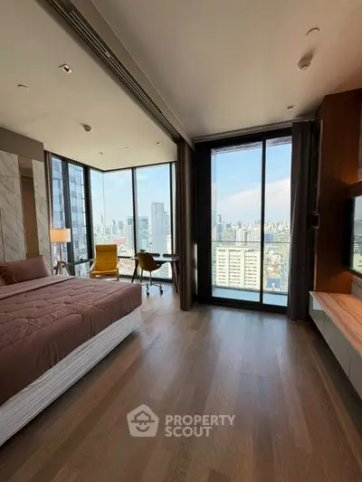 Luxurious bedroom with stunning city view and modern furnishings in high-rise apartment.