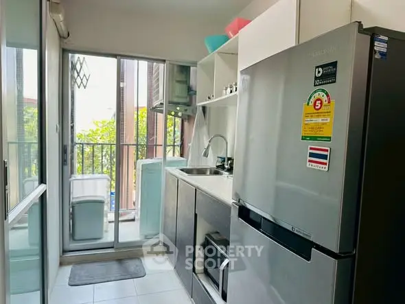 Modern kitchen with sleek appliances and balcony view, perfect for urban living.