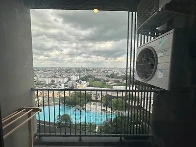 Stunning high-rise balcony view with cityscape and pool, featuring air conditioning unit.