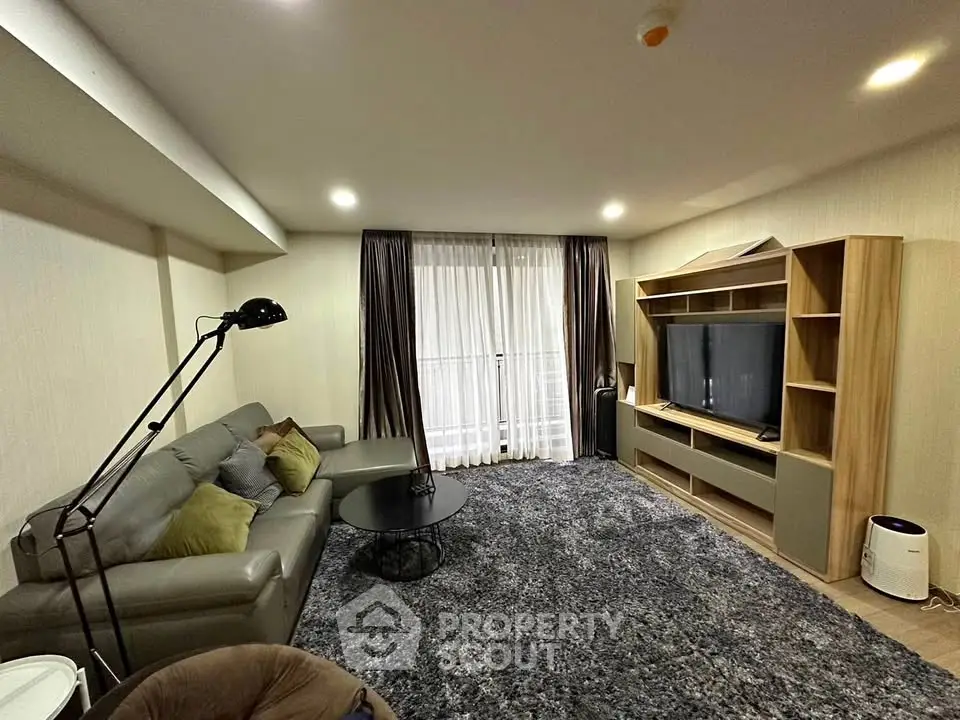 Spacious living room with modern decor and large TV unit