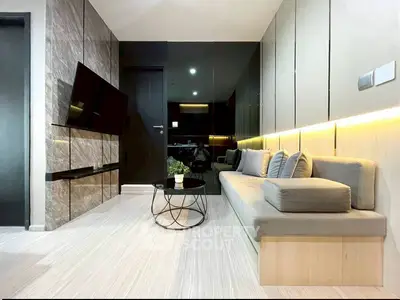 Modern living room with sleek design, wall-mounted TV, and stylish furniture in a contemporary apartment.