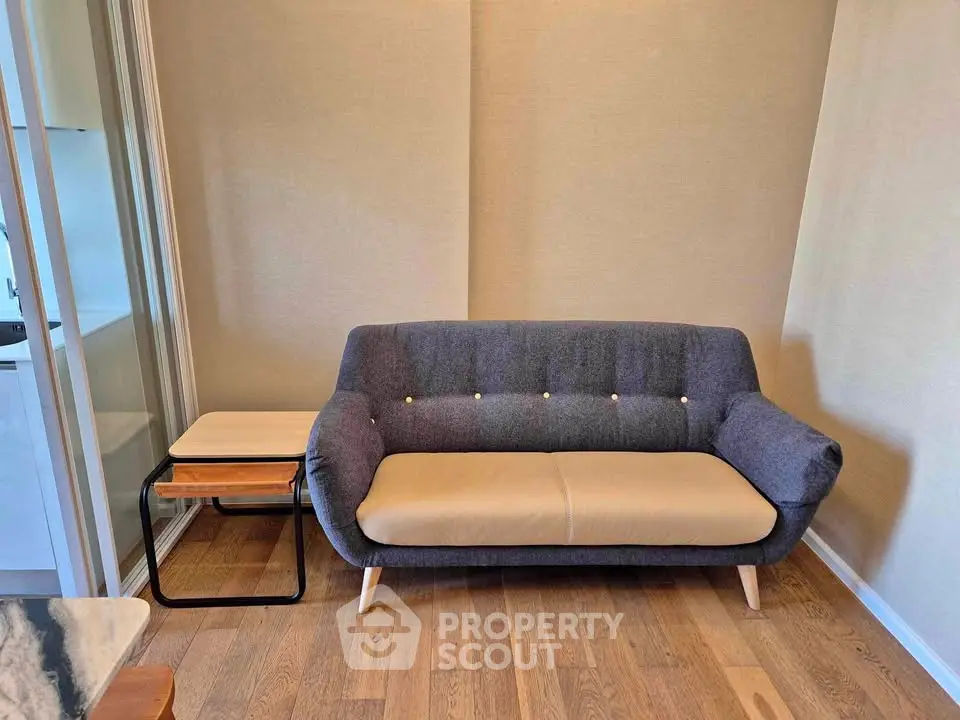 Modern living room with stylish sofa and wooden flooring, perfect for cozy relaxation.