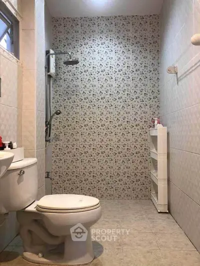 Charming bathroom with floral tile accent wall and modern fixtures.