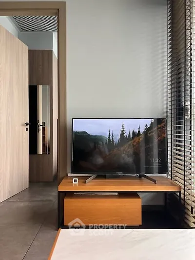 Modern living room with sleek TV setup and wooden furniture