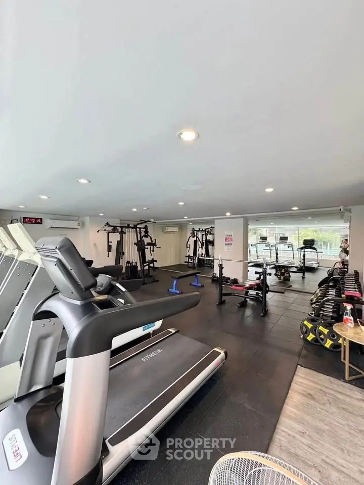 Modern gym with state-of-the-art equipment in a residential building, perfect for fitness enthusiasts.