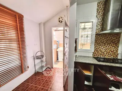 Charming kitchen with open layout and gas stove, featuring stylish mosaic backsplash and ample natural light.