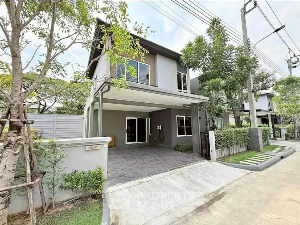 Modern two-story house with driveway and lush greenery in a serene neighborhood.
