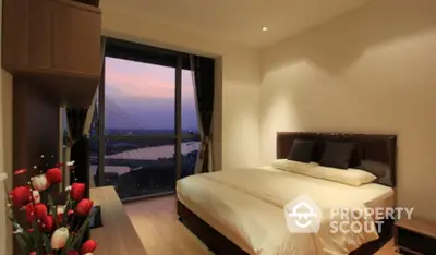 Elegant bedroom with a large window offering a stunning sunset view over a serene river, complemented by warm lighting and modern decor.