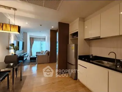 Modern open-layout kitchen and living room with sleek design and natural light.