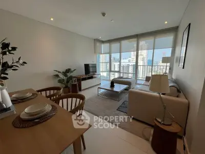 Spacious modern living room with city view, elegant furniture, and natural light.