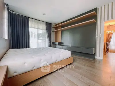 Modern bedroom with stylish shelving and large window for natural light