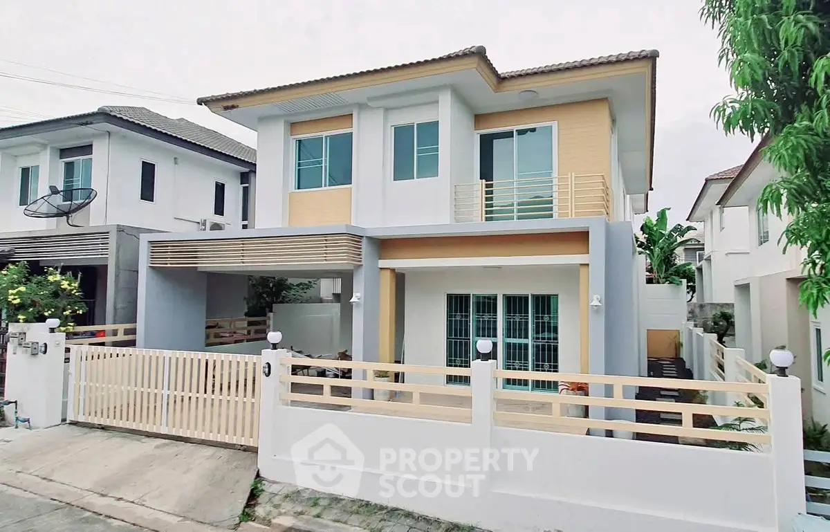 Modern two-story house with gated entrance and contemporary design.