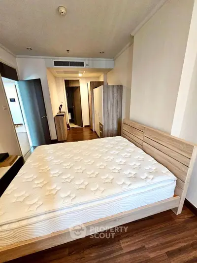 Spacious bedroom with modern wooden furniture and cozy ambiance, perfect for relaxation.