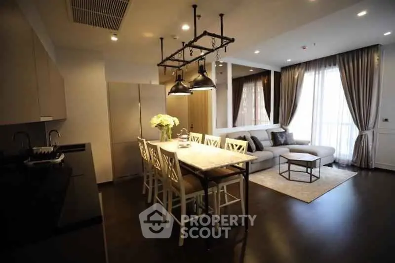 Luxurious open-plan living room and kitchen with elegant decor and ample natural light.