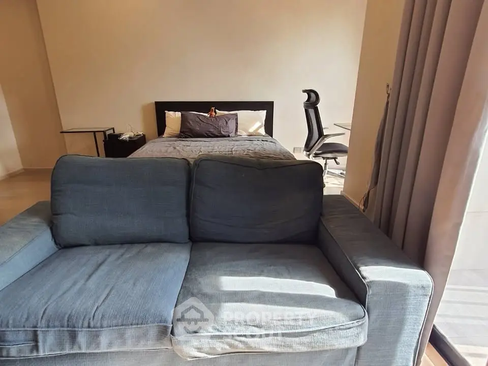Modern studio apartment with cozy bed and stylish sofa, perfect for urban living.