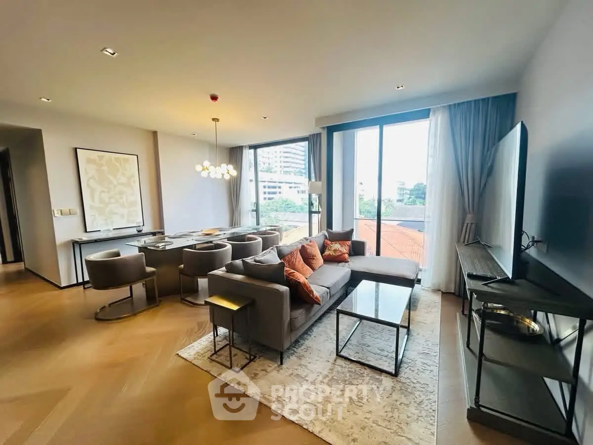 Spacious modern living room with elegant decor and large windows offering a city view.