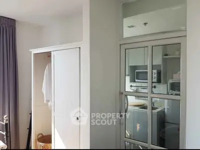 Modern apartment interior with kitchen and wardrobe, featuring sleek design and natural light.