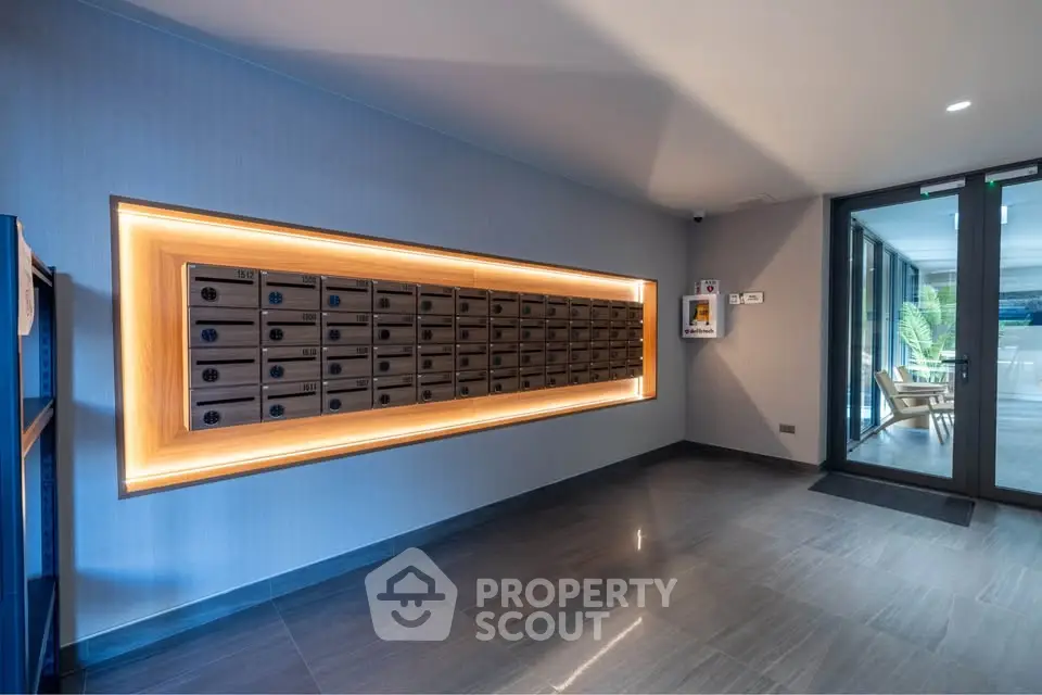 Modern apartment building lobby with illuminated mailboxes and sleek design.