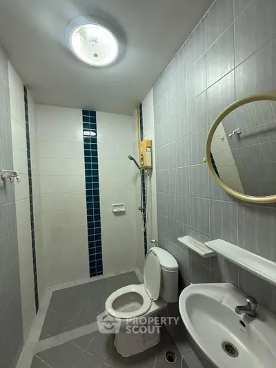 Compact bathroom with modern fixtures and stylish tile design, perfect for urban living.