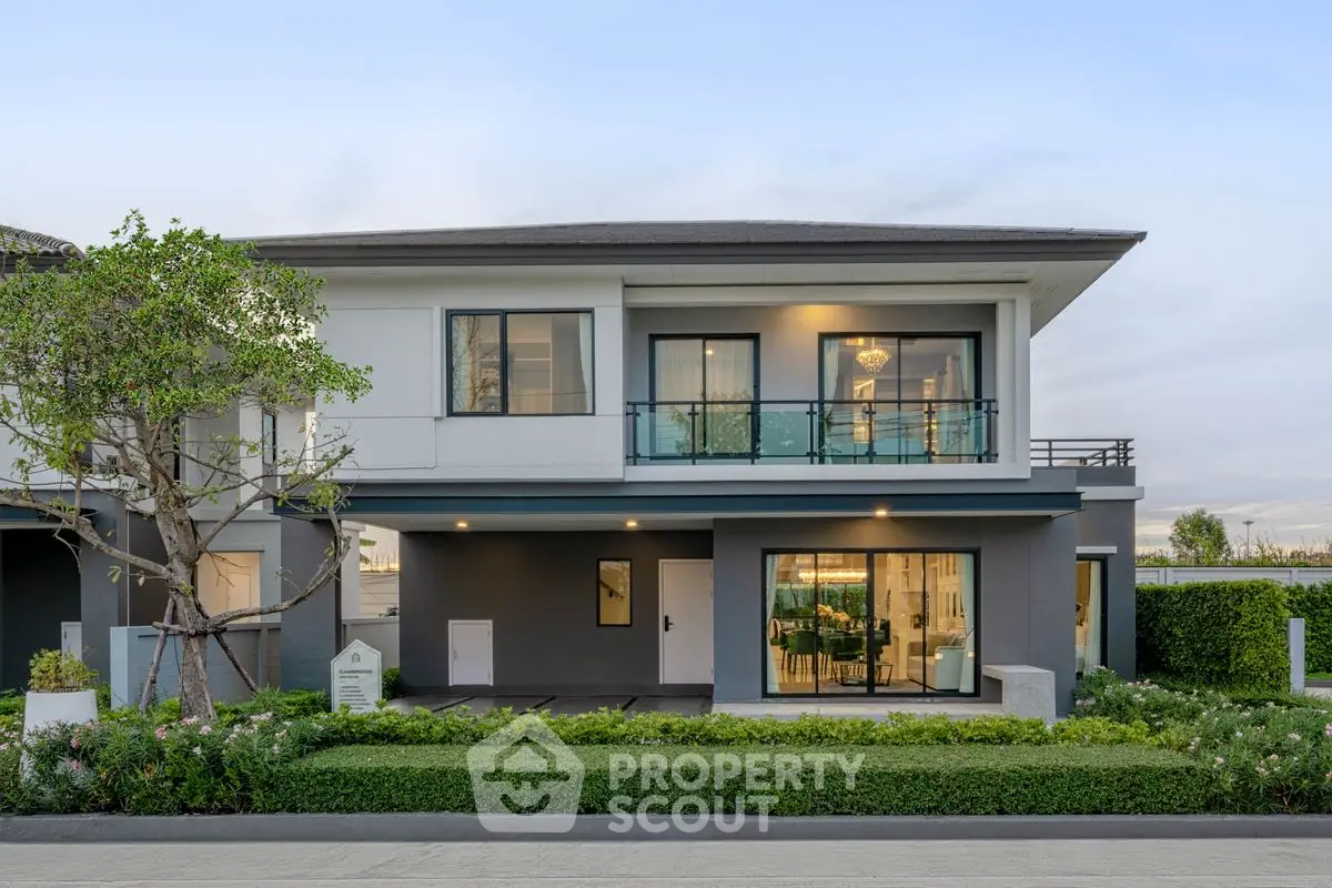 Modern two-story house with large windows and landscaped garden