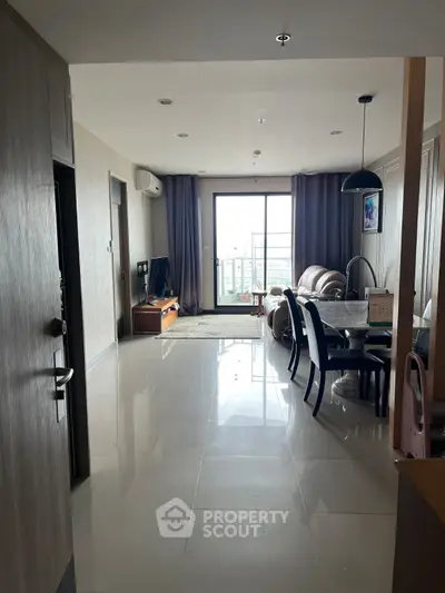 Spacious living room with modern decor and balcony view in a stylish apartment.