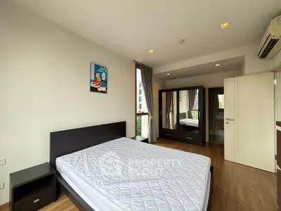 Spacious bedroom with modern furniture and large window offering natural light.