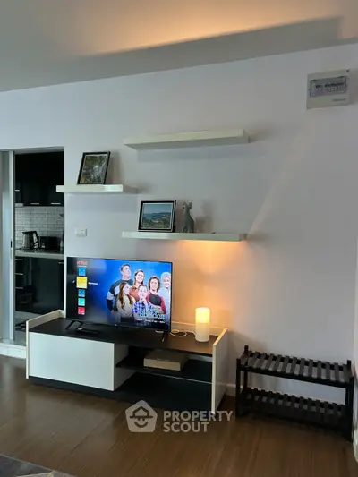 Modern living room with sleek TV stand and open kitchen layout