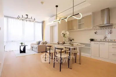 Modern open-plan living room and kitchen with stylish lighting and elegant decor.